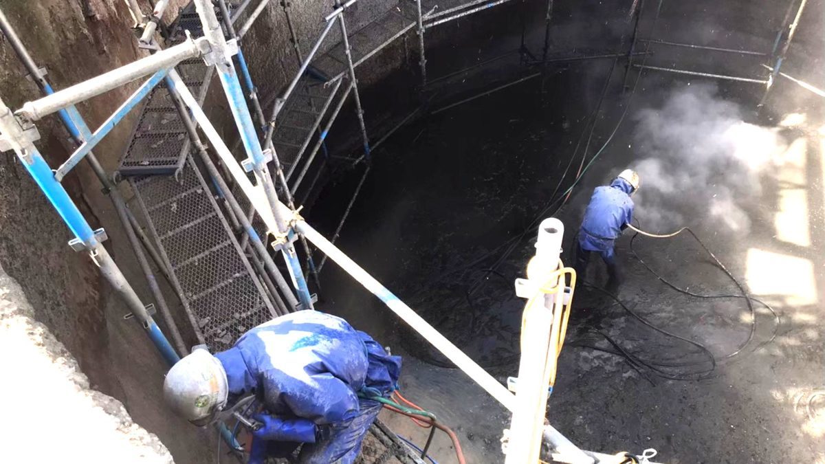 工場内の深い処理槽。底部まで足場を下ろして施工する